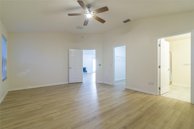 spare room featuring ceiling fan, light hardwood / wood-style floors, and vaulted ceiling