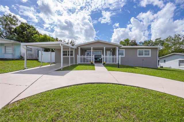 view of front of home with a front lawn, covered porch, and a carport