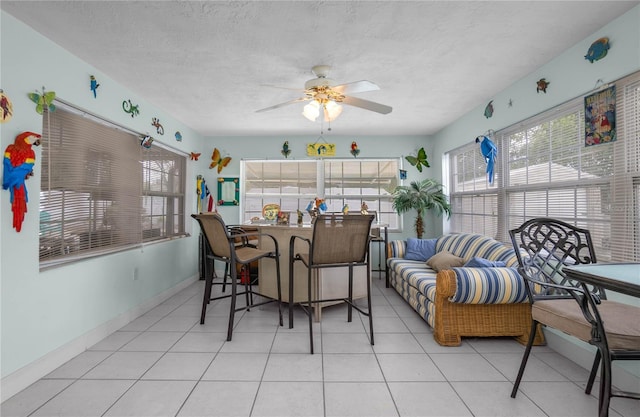 dining area with a textured ceiling, ceiling fan, a healthy amount of sunlight, and light tile patterned flooring