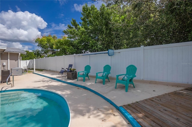 view of swimming pool with cooling unit and a wooden deck