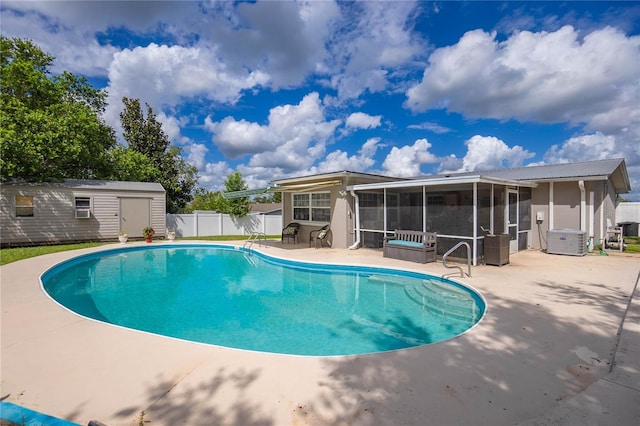 view of pool featuring a sunroom, a shed, central air condition unit, and a patio