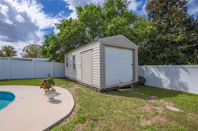 view of outdoor structure with a fenced in pool and a yard