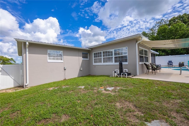 back of property featuring a yard and a patio