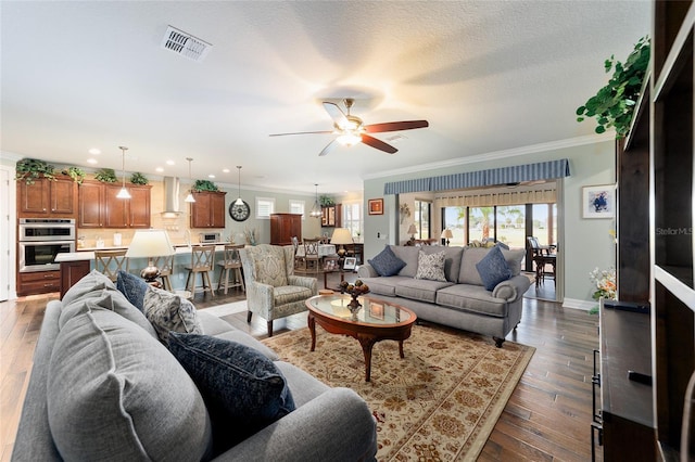 living room featuring a textured ceiling, dark hardwood / wood-style flooring, ceiling fan, and crown molding