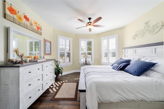 bedroom featuring ceiling fan, dark hardwood / wood-style floors, and a textured ceiling