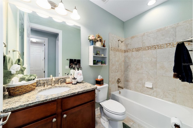 full bathroom featuring vanity, tiled shower / bath combo, toilet, and tile patterned flooring