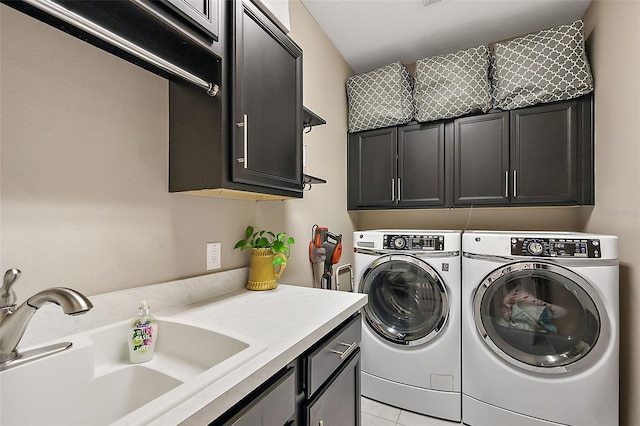 laundry area featuring cabinets, light tile patterned floors, sink, and washing machine and dryer