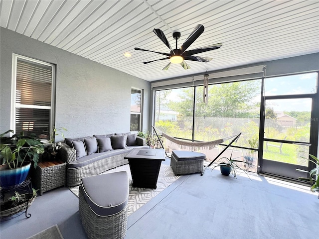 sunroom with ceiling fan and wooden ceiling