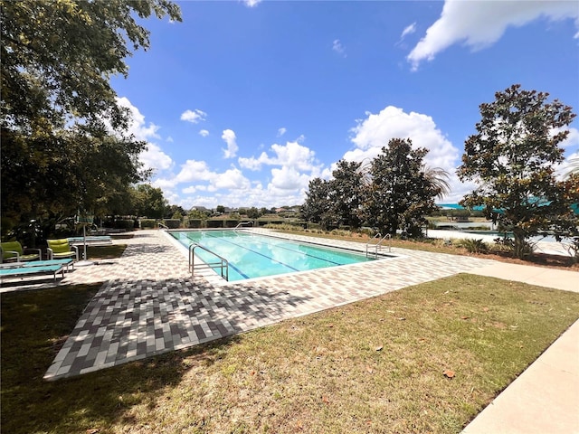 view of swimming pool featuring a yard and a patio area