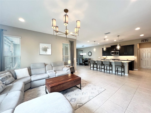 tiled living room with a notable chandelier and sink