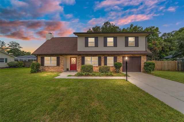 view of front property featuring a garage and a yard