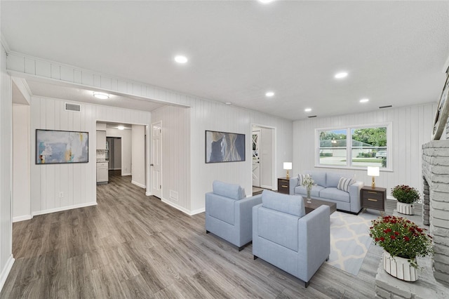 living room with light wood-type flooring and wooden walls