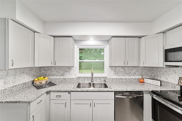 kitchen featuring decorative backsplash, sink, white cabinets, and appliances with stainless steel finishes