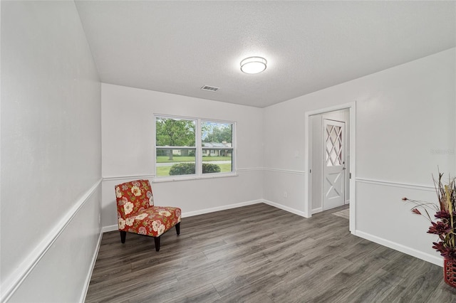 living area with dark hardwood / wood-style flooring and a textured ceiling