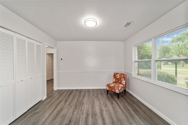 unfurnished room featuring dark hardwood / wood-style flooring and a textured ceiling