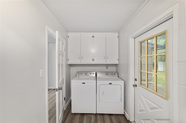 laundry area featuring washing machine and dryer, dark hardwood / wood-style flooring, and cabinets