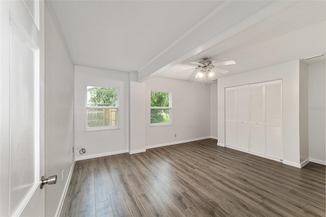 unfurnished bedroom featuring beam ceiling, ceiling fan, and dark wood-type flooring