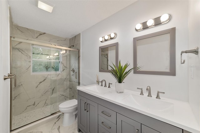 bathroom with a textured ceiling, vanity, toilet, and a shower with shower door