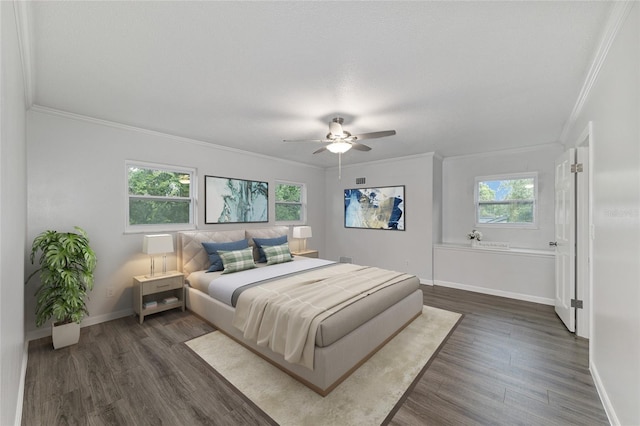 bedroom featuring multiple windows, dark hardwood / wood-style floors, ceiling fan, and ornamental molding