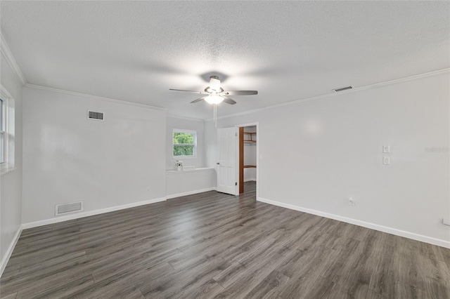 empty room with a textured ceiling, ceiling fan, ornamental molding, and dark wood-type flooring