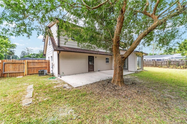 rear view of house featuring cooling unit, a yard, and a patio