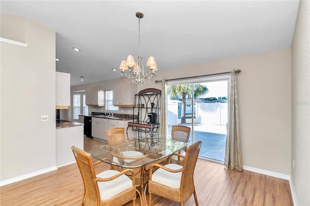 dining space with a notable chandelier and light wood-type flooring