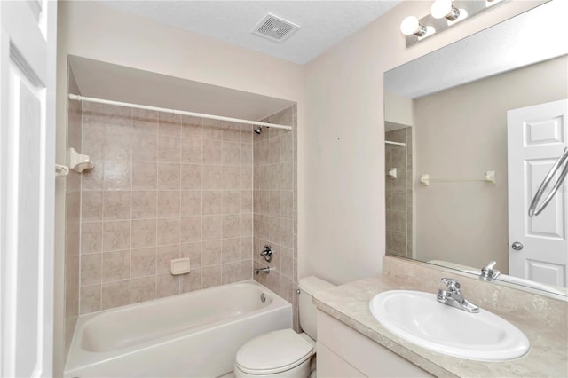 full bathroom with toilet, vanity, a textured ceiling, and tiled shower / bath