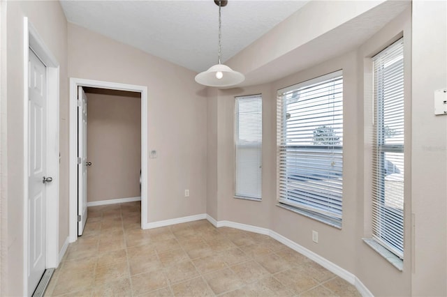 tiled spare room with a textured ceiling and vaulted ceiling