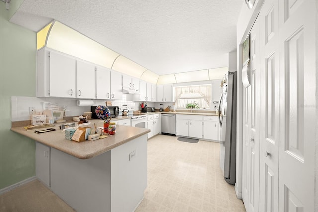 kitchen featuring kitchen peninsula, white cabinets, stainless steel appliances, and a textured ceiling