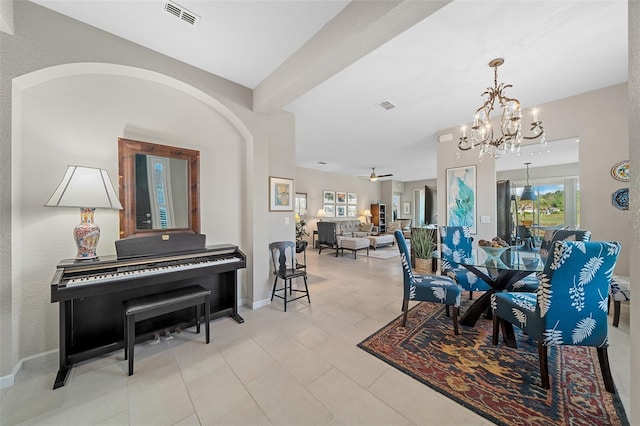 dining room with light tile patterned flooring and ceiling fan with notable chandelier