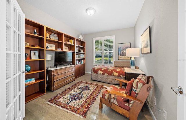 living area with french doors and light hardwood / wood-style floors