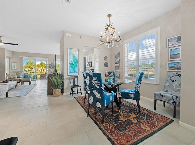 tiled dining space featuring ceiling fan with notable chandelier