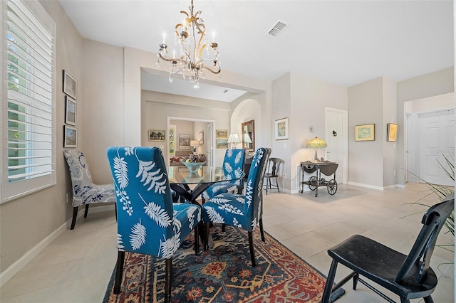 dining space featuring light tile patterned floors and an inviting chandelier