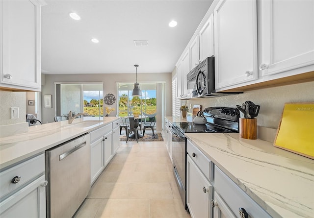 kitchen with white cabinetry, light stone counters, decorative light fixtures, light tile patterned floors, and appliances with stainless steel finishes