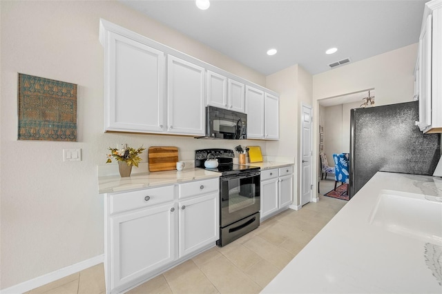 kitchen featuring black appliances, white cabinets, light tile patterned floors, and light stone counters