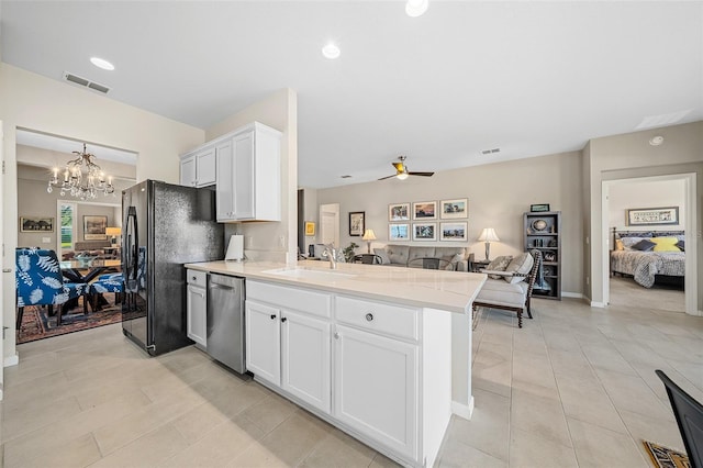 kitchen with ceiling fan with notable chandelier, kitchen peninsula, appliances with stainless steel finishes, decorative light fixtures, and white cabinetry