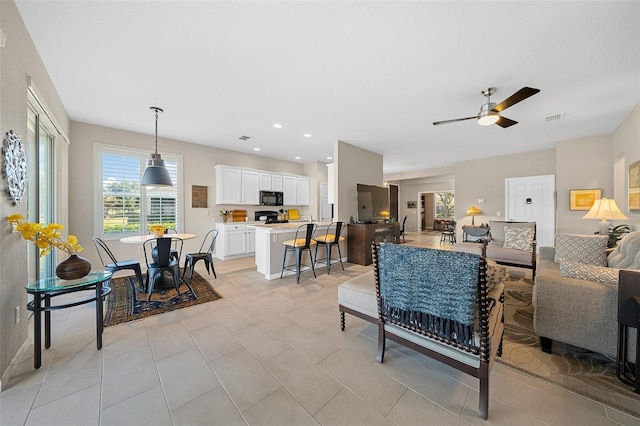 living room with ceiling fan and light tile patterned floors