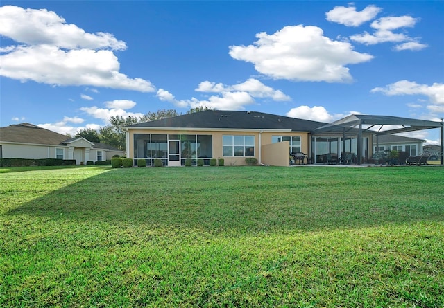 rear view of house featuring a yard and glass enclosure