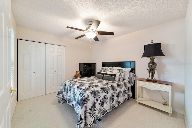 bedroom with ceiling fan, carpet floors, a textured ceiling, and a closet