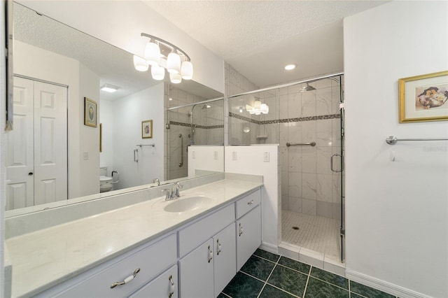 bathroom with tile patterned floors, vanity, a textured ceiling, a shower with door, and toilet