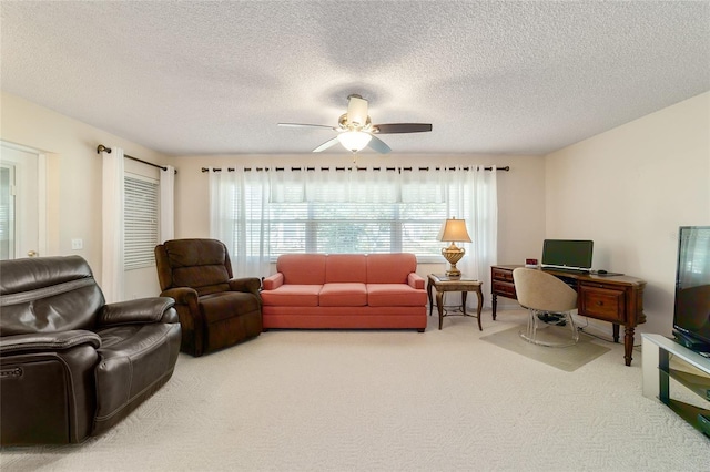 living room featuring carpet, ceiling fan, and a textured ceiling