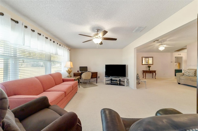 living room with carpet flooring, ceiling fan, and a textured ceiling