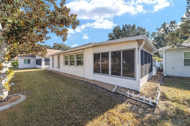 rear view of property with a sunroom and a lawn