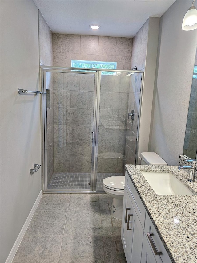 bathroom with toilet, vanity, tile patterned floors, and a shower with door