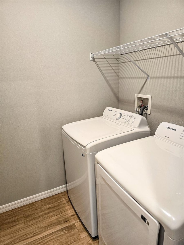 laundry room featuring hardwood / wood-style floors and washing machine and clothes dryer