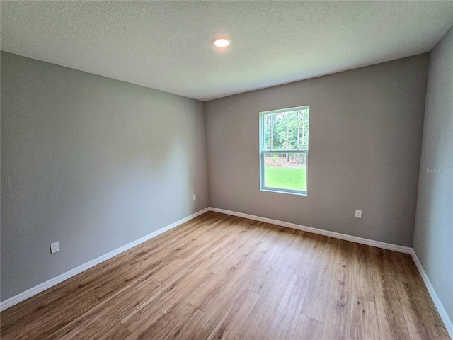 empty room featuring light hardwood / wood-style flooring and a textured ceiling