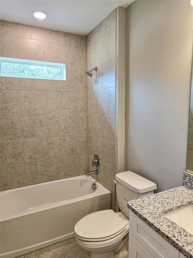 full bathroom with tile patterned flooring, vanity, tiled shower / bath combo, and toilet