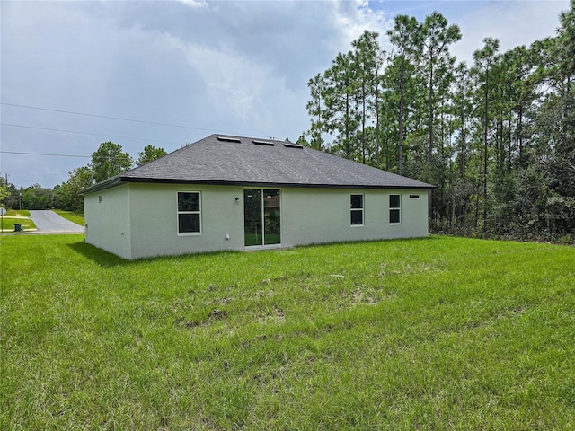 back of property featuring a yard