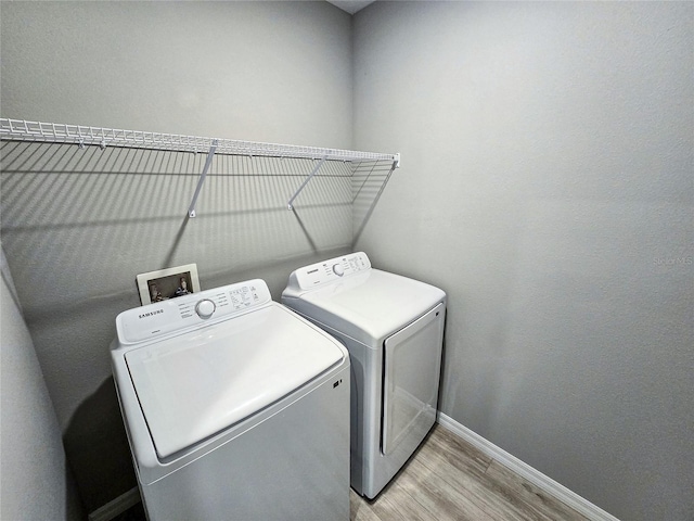 laundry area featuring light wood-type flooring and washer and clothes dryer