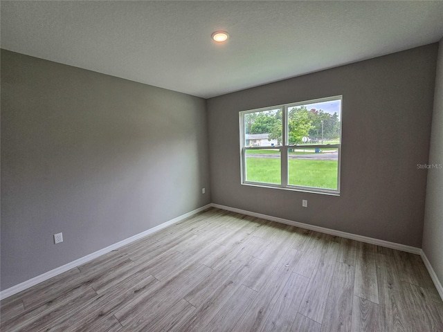 empty room featuring light hardwood / wood-style flooring and a textured ceiling